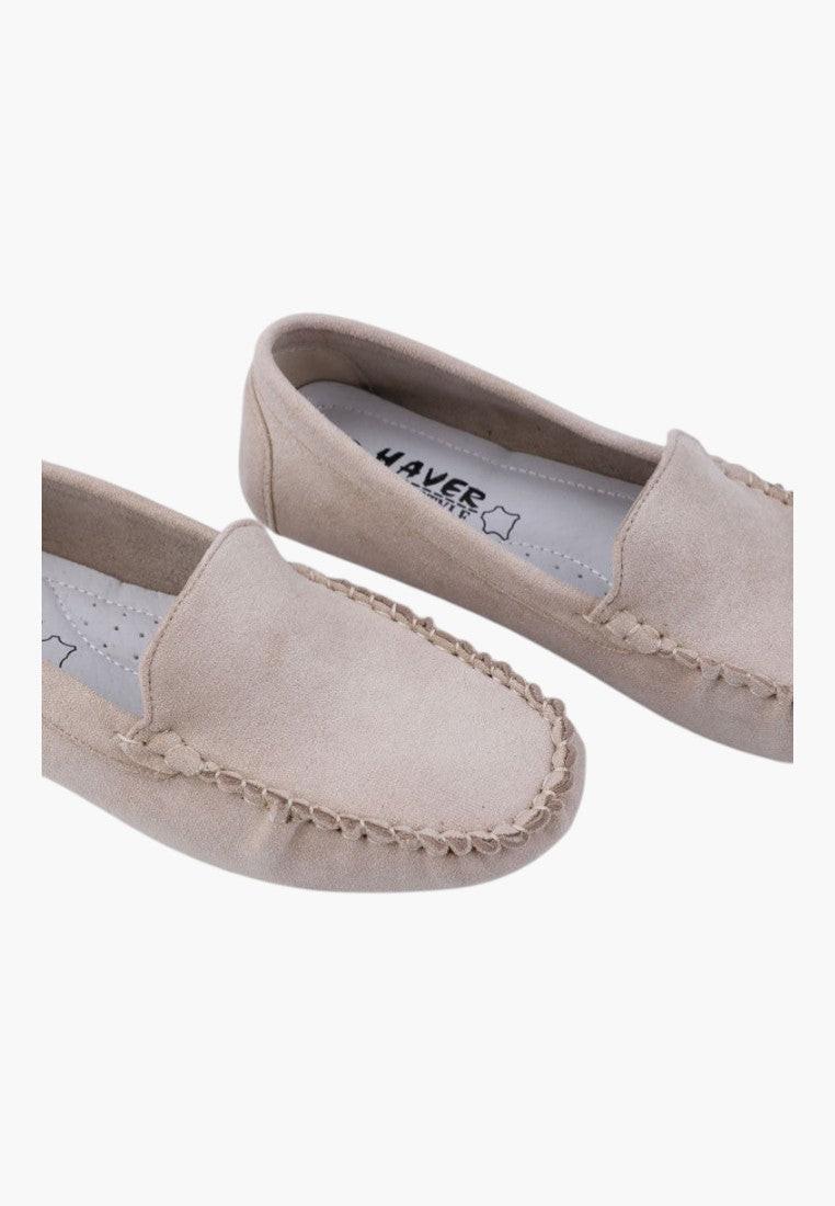 Side view of beige slip-on shoes with flat sole on a white background