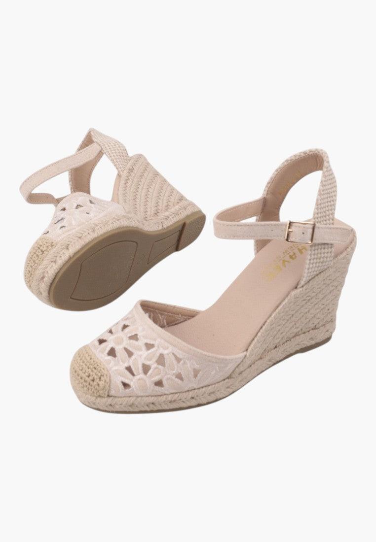 Side view of beige wedge sandals featuring an ankle strap and platform sole.