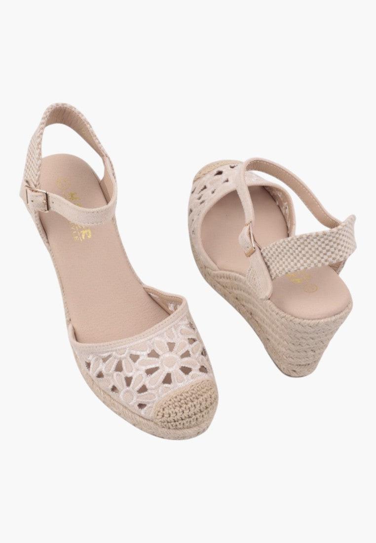 Side view of beige wedge sandals featuring ankle strap and platform sole.