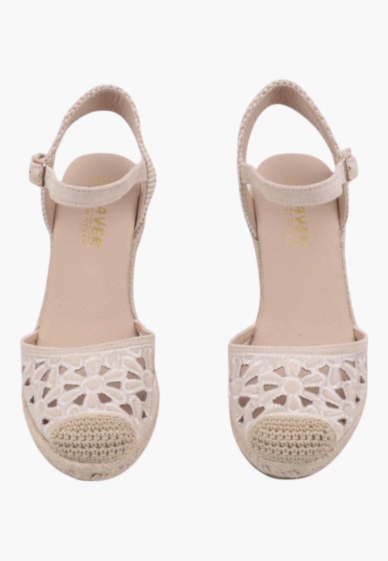 Top view of beige wedge sandals with ankle strap and woven design.