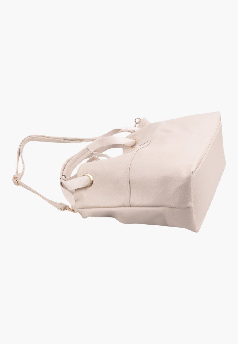 Side view of a beige handbag with a long strap.