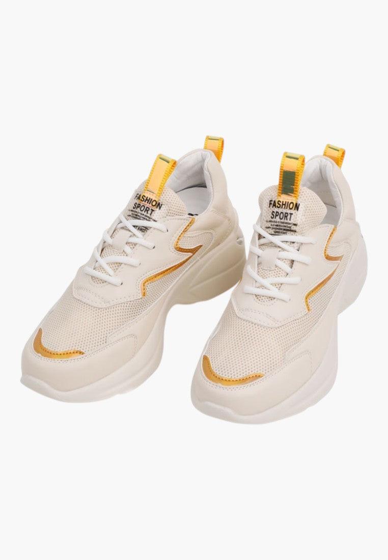 Detail of beige lace-up sneakers with chunky sole on a white background