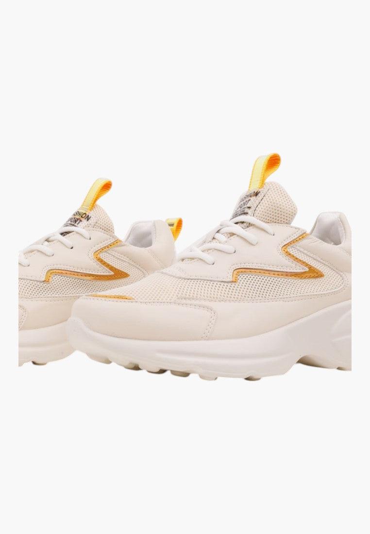 Side view of beige sneakers highlighting a thick sole and stylish design on a white background