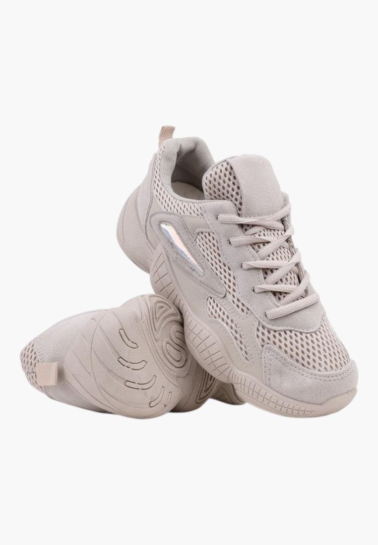 Detail view of beige sneakers showcasing lace-up closure on a white background