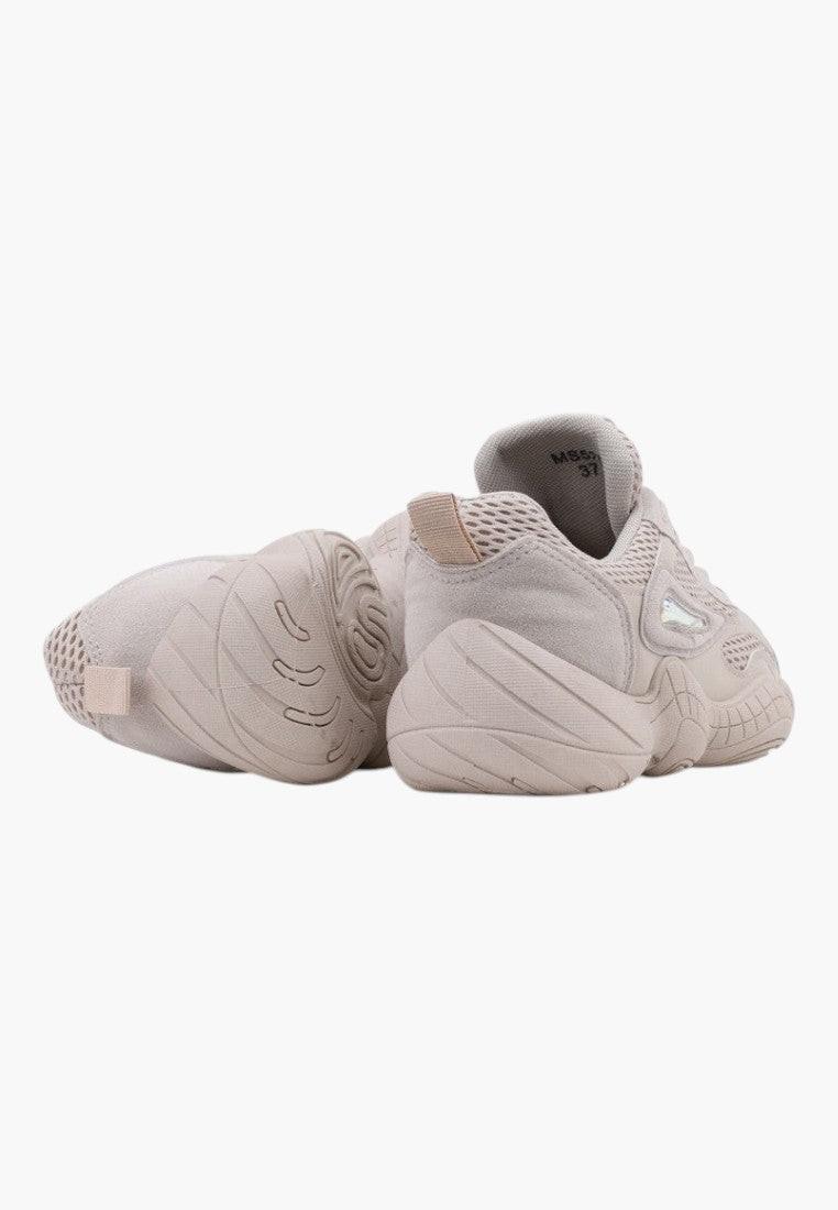 Side view of beige sneakers with chunky sole and soft material on a white background