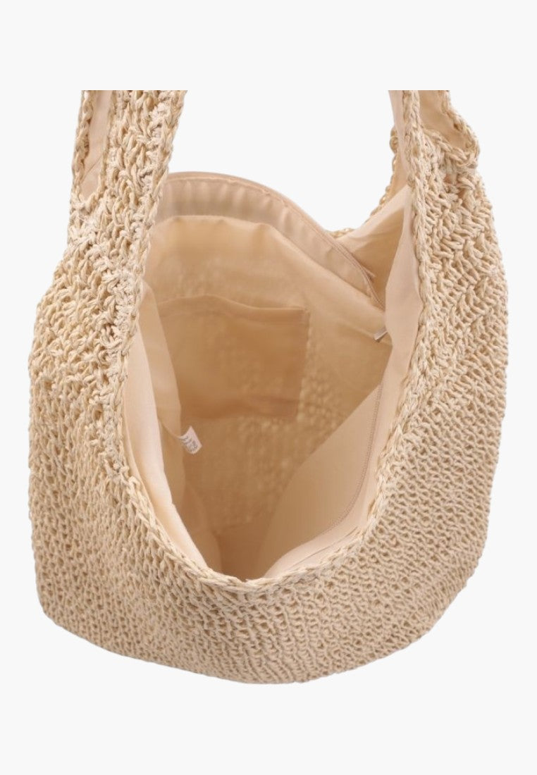 Widok detalu beżowej torby plecionej z otwartym górnym wejściem na białym tle