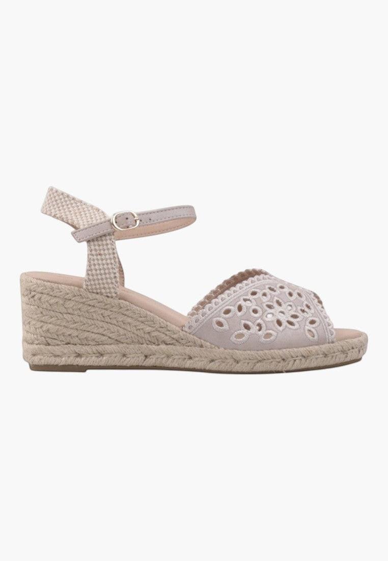 Back view of beige wedge sandals with ankle strap and wedge heel on a white background