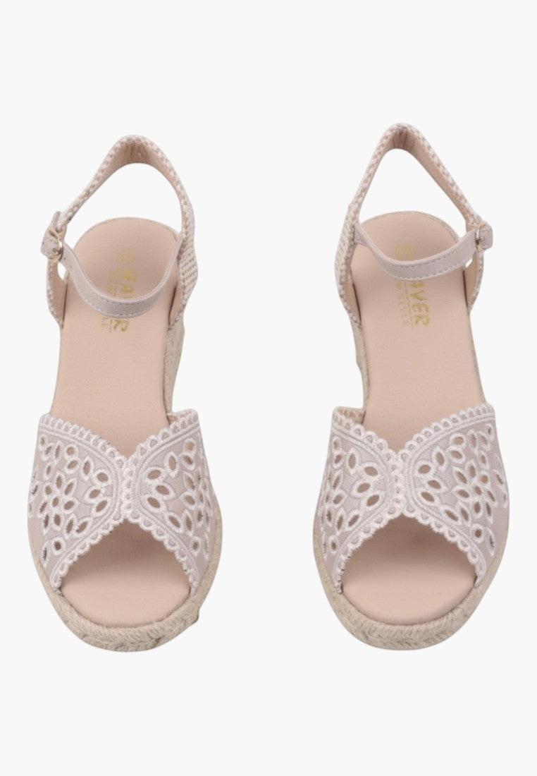 Front view of beige wedge sandals featuring cross strap on a white background