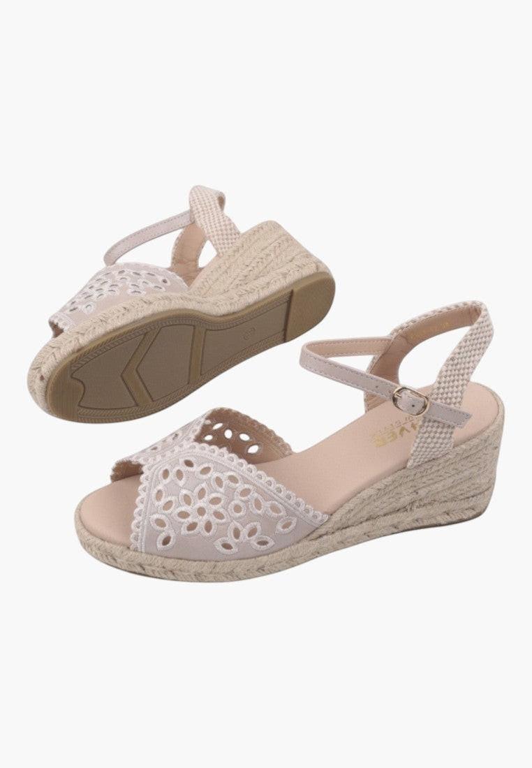 Side angle of beige wedge sandals with ankle strap and wedge heel on a white background