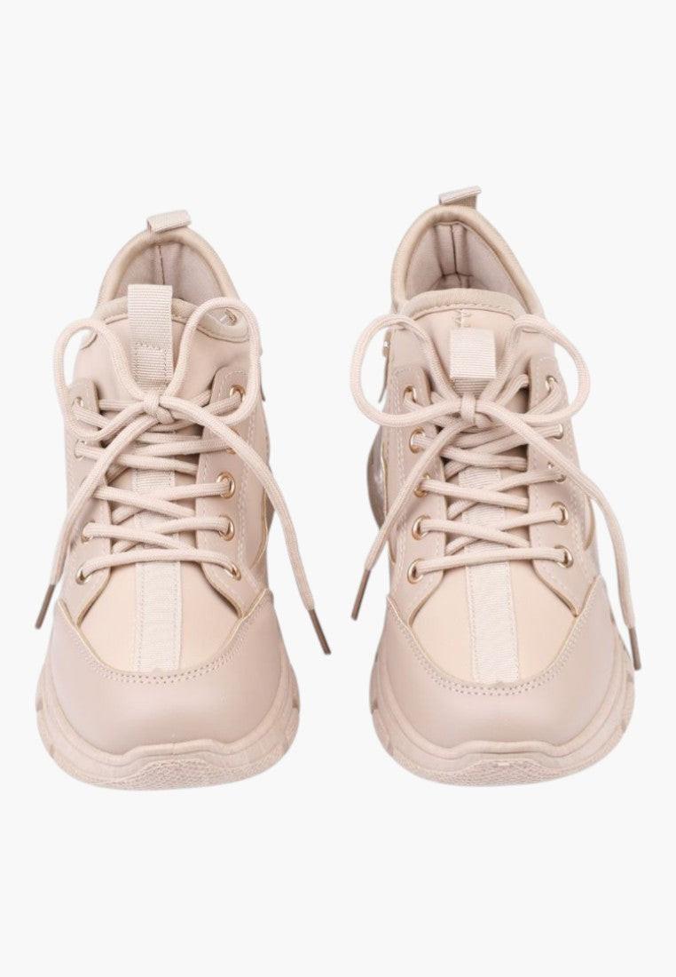 Back view of beige sneakers highlighting the heel detail.