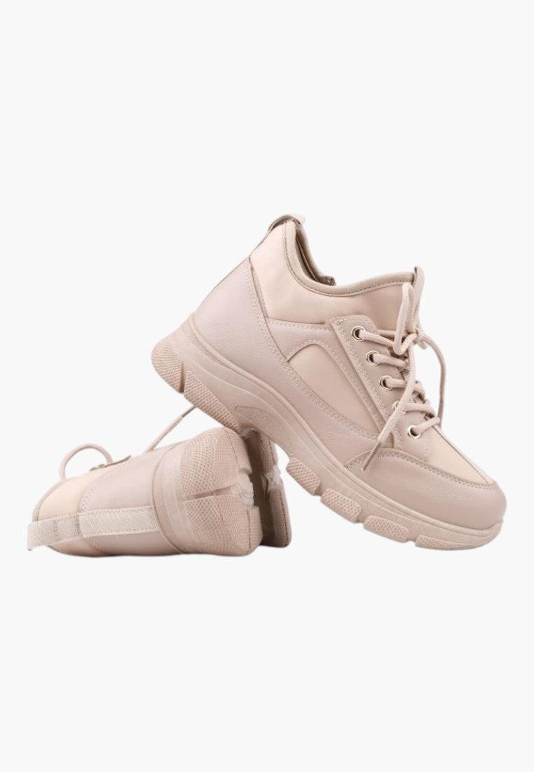 Close-up detail of beige sneakers featuring a textured surface and lace-up design.