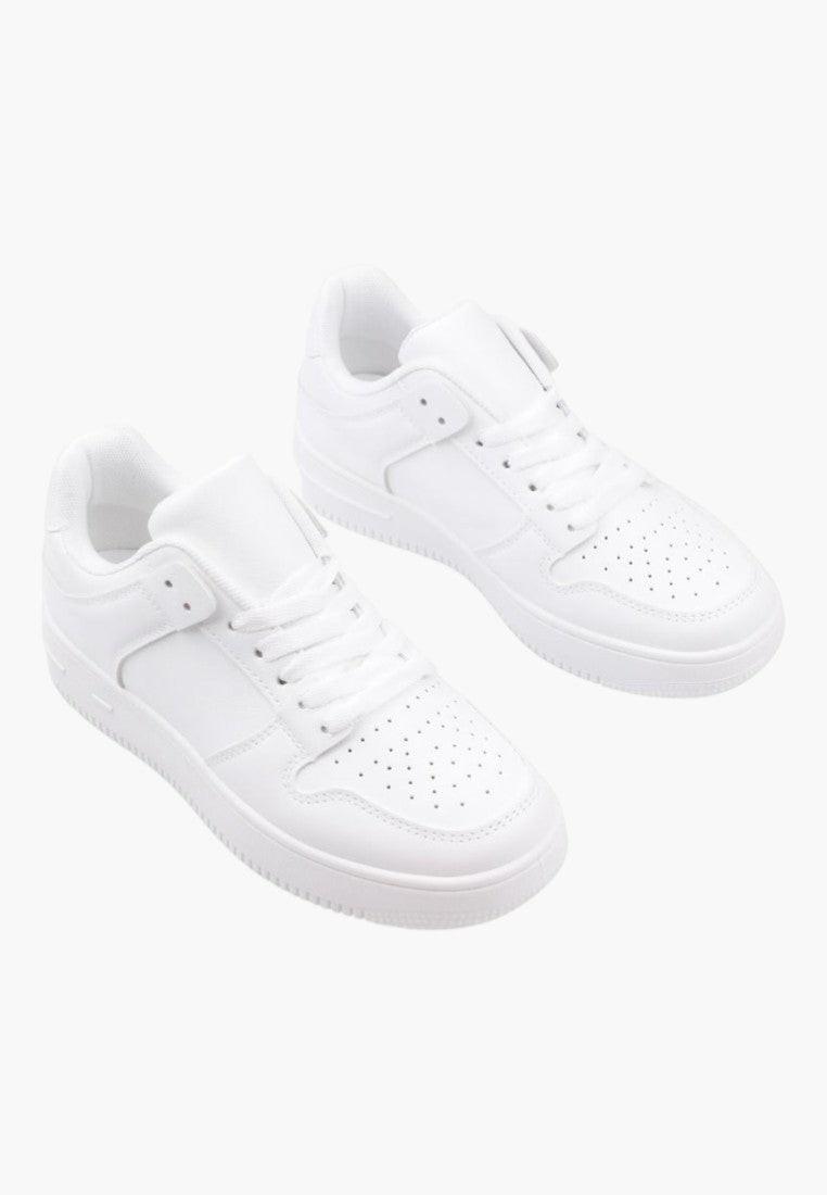 Detail view of white sneakers with lace-up closure and padded collar.