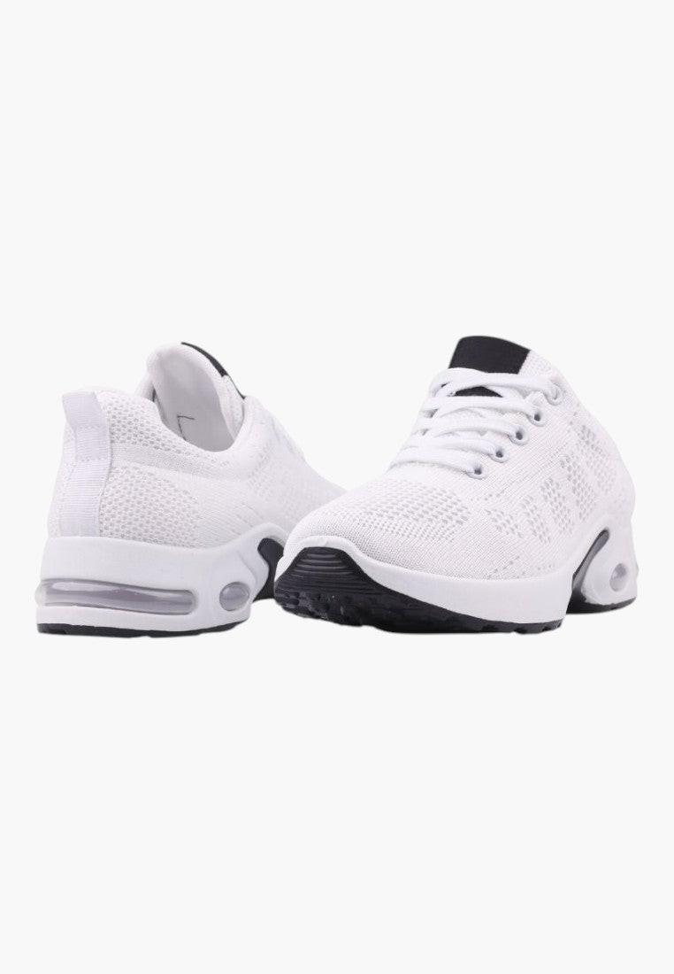 Detal podeszwy białych sneakersów damskich z przewiewnego materiału.