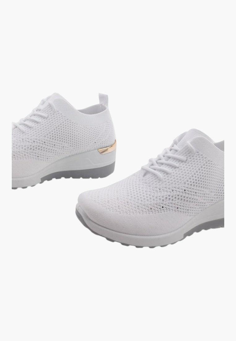 Białe sneakersy damskie sportowe na koturnie, stylizacja lifestyle, widok z boku.