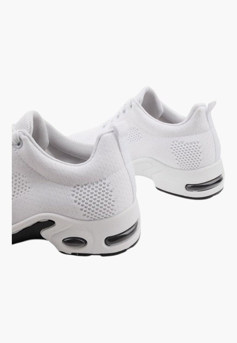 Zbliżenie na teksturowany materiał białych sneakersów damskich.