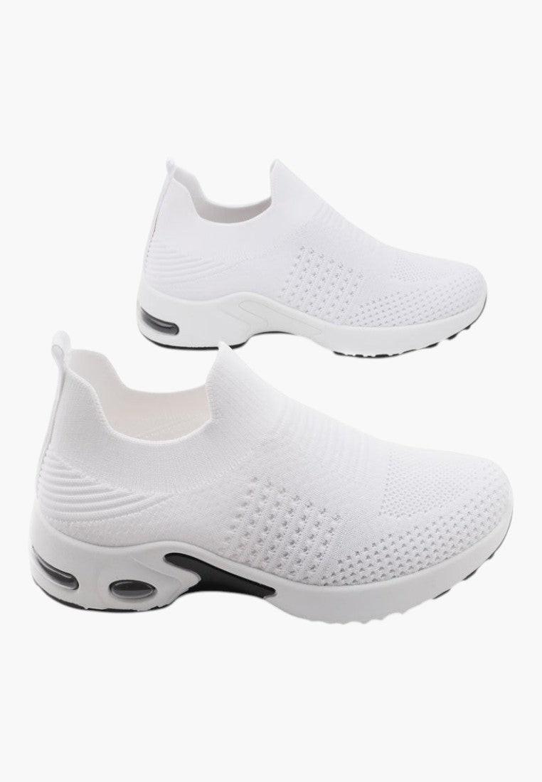 Widok z bliska białych wsuwanych sneakersów damskich z teksturowanym wierzchem.