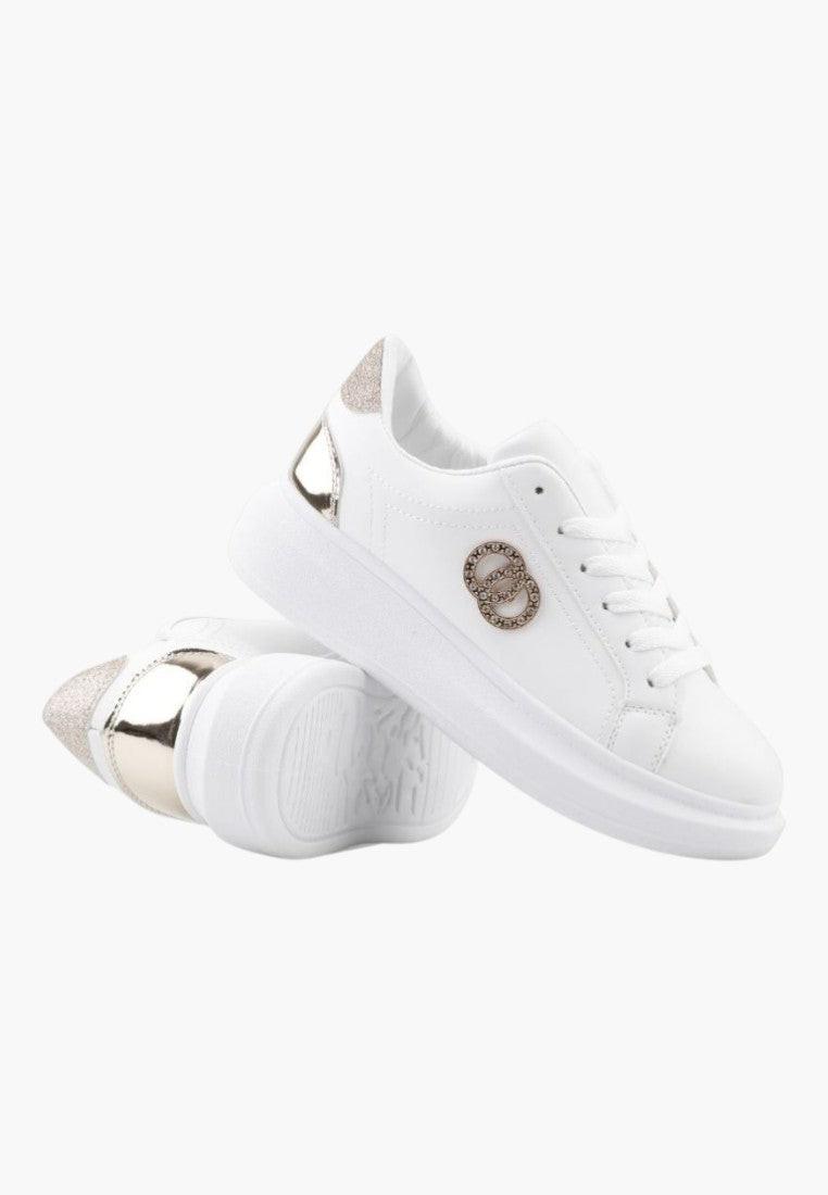 Detal białych sneakersów z okrągłym noskiem i kryształkami.