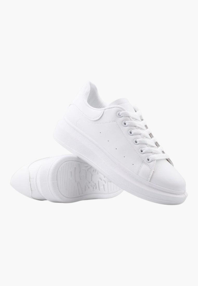Widok z boku białych sneakersów z grubą podeszwą.