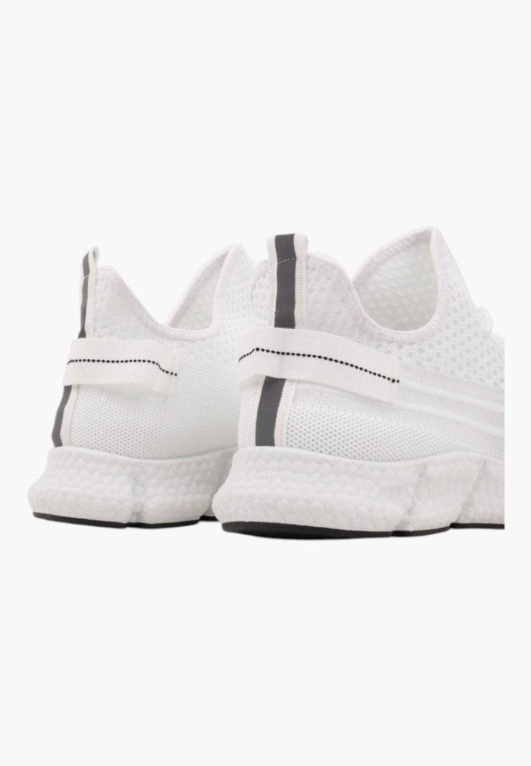 Zbliżenie detalu białych sneakersów z paskami.