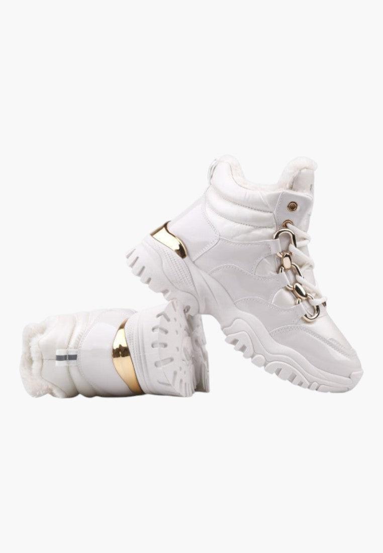 Białe sneakersy z złotymi akcentami, widok z boku.