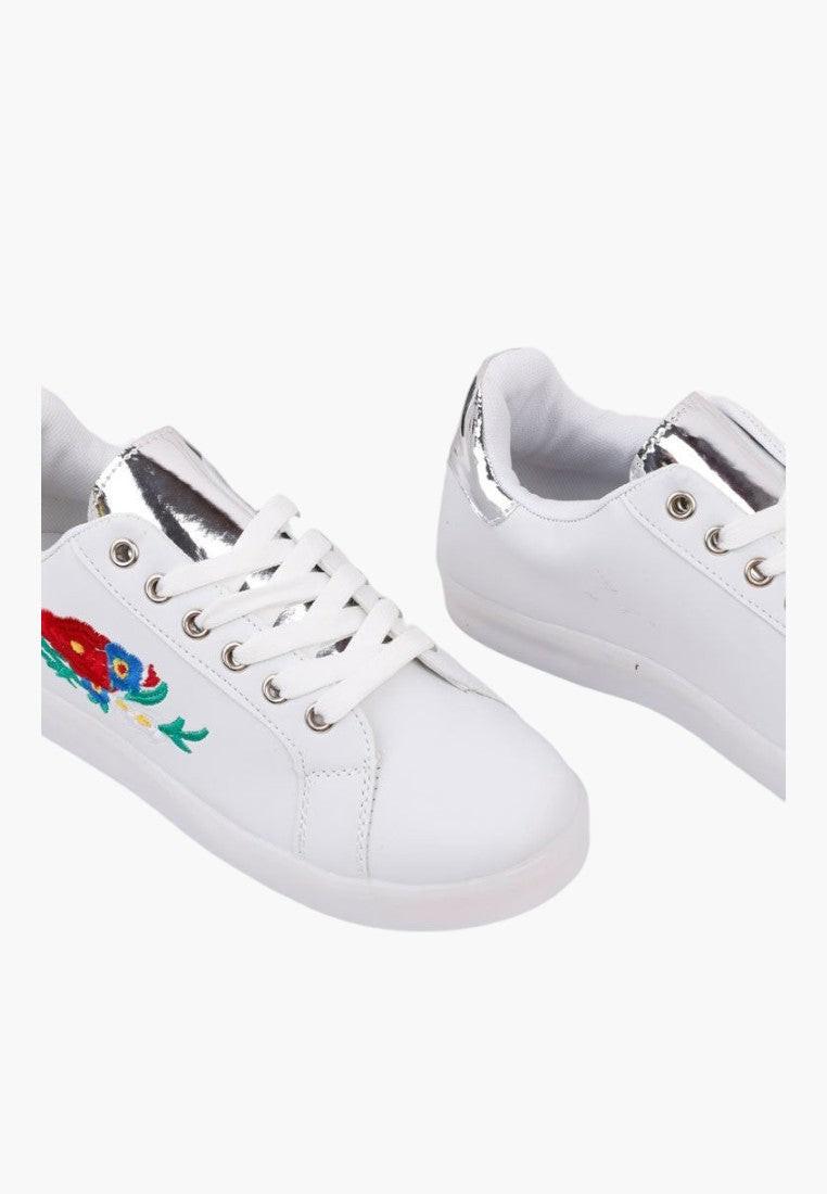 Białe sportowe buty z ekoskóry, widok z boku, kolorowy design.