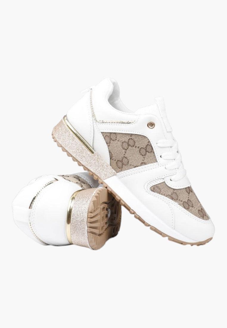 Zbliżenie na materiał biało-złotych sneakersów damskich