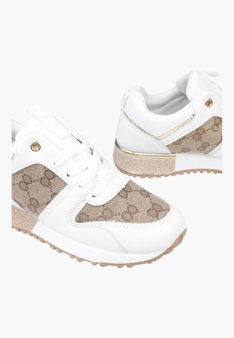 Zbliżenie na podeszwę biało-złotych sneakersów damskich