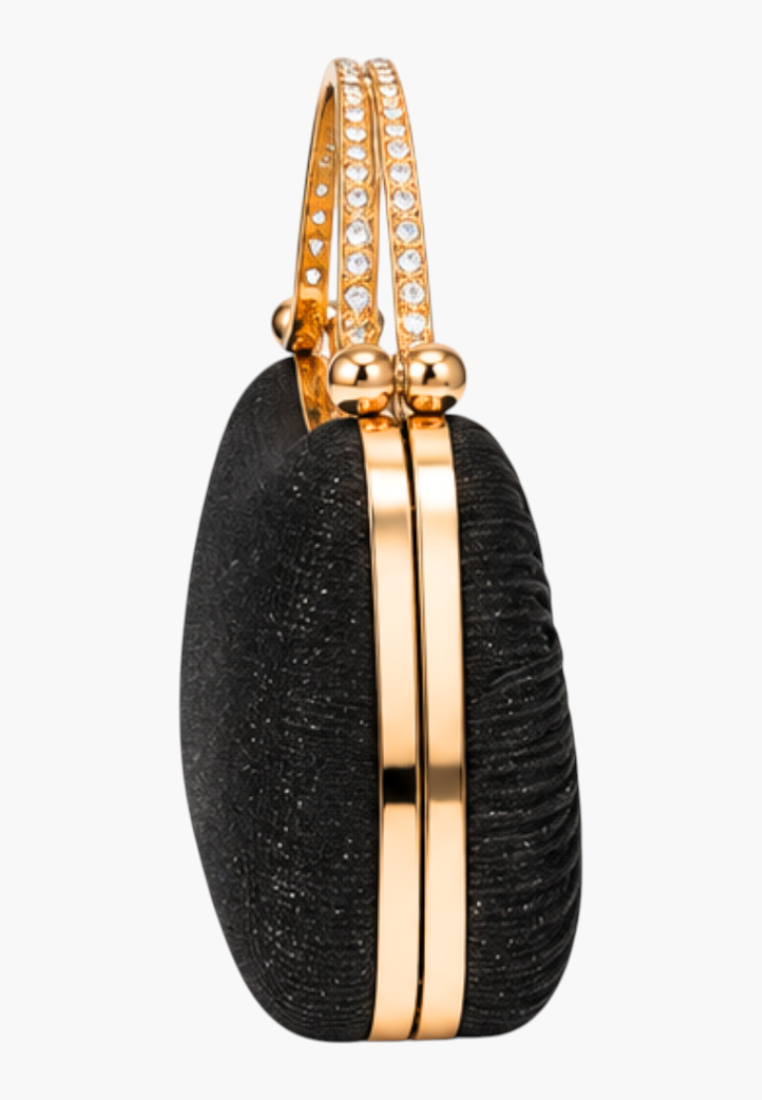 Close-up detail of the black handbag highlighting gold hardware and textured fabric.