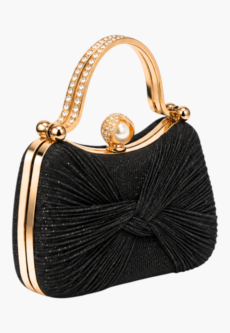 Side view of the black handbag showcasing gold accents and a slim profile.