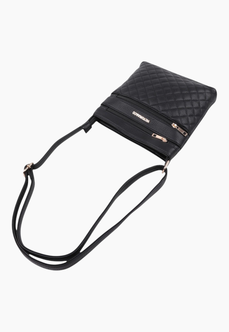 Side view of the black handbag highlighting two zipper pockets and slim profile.