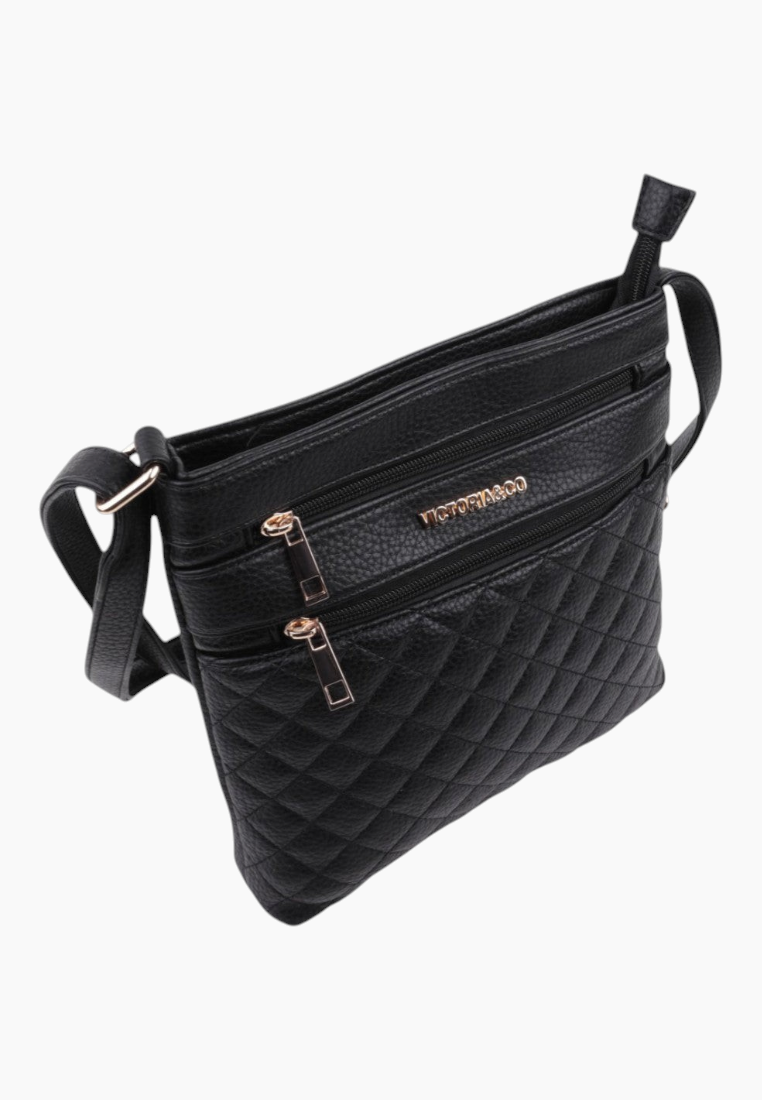 Back view of the black quilted handbag showing two front pockets and adjustable strap.