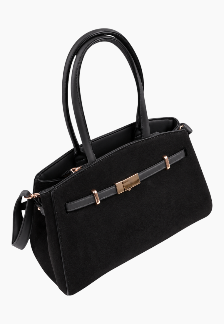 Side view of the black handbag featuring two handles and gold hardware.