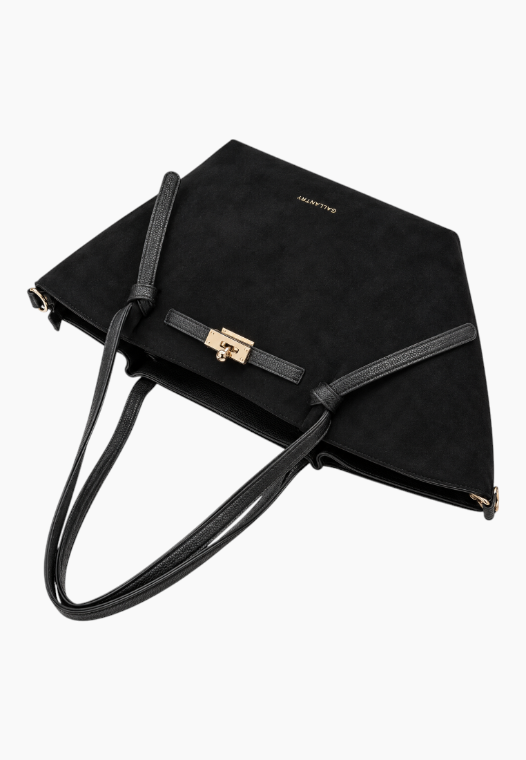Detail shot of the black handbag highlighting the flat base and zipper pocket.