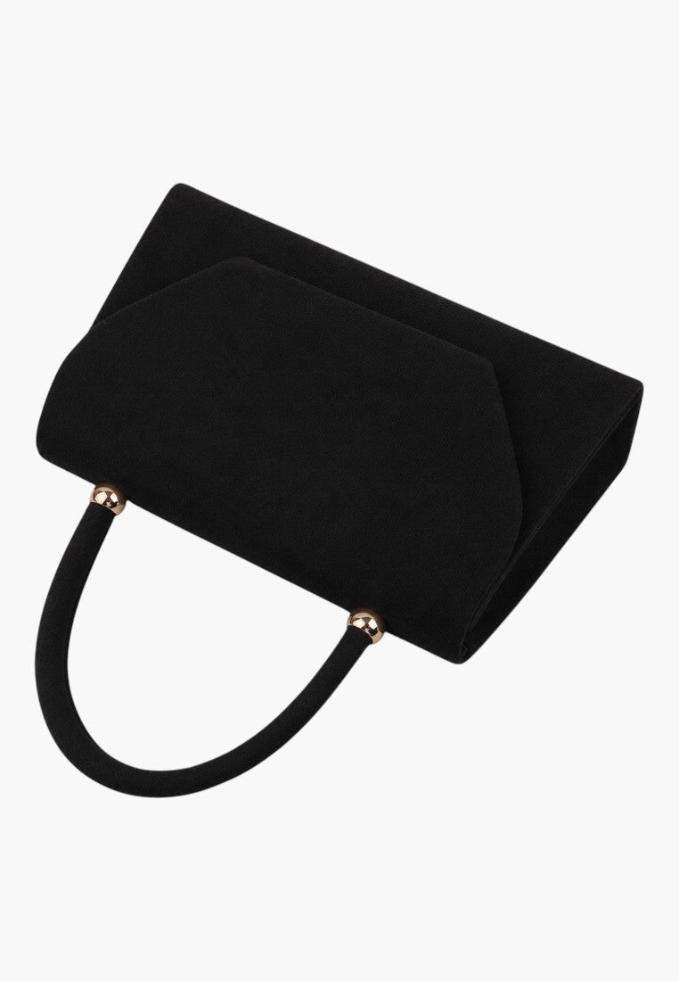 Close-up detail of a black handbag highlighting its textured surface and flap closure on a white background.