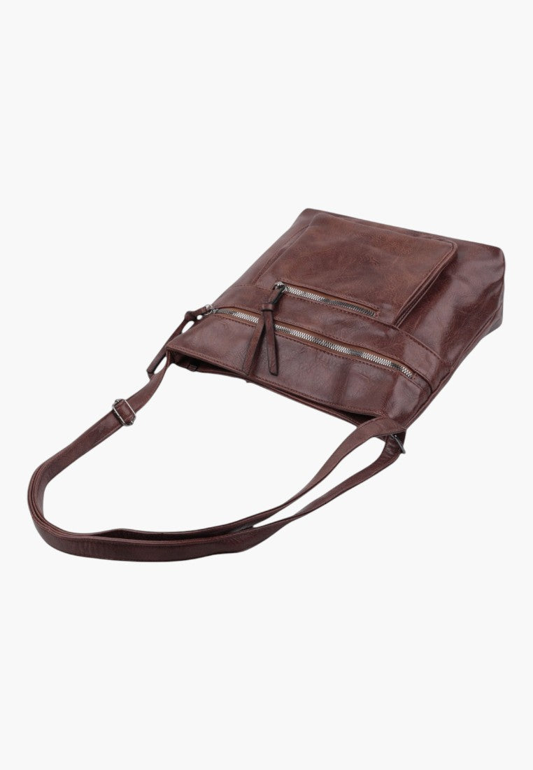 Other angle of brown faux leather crossbody bag featuring adjustable strap and flat design.