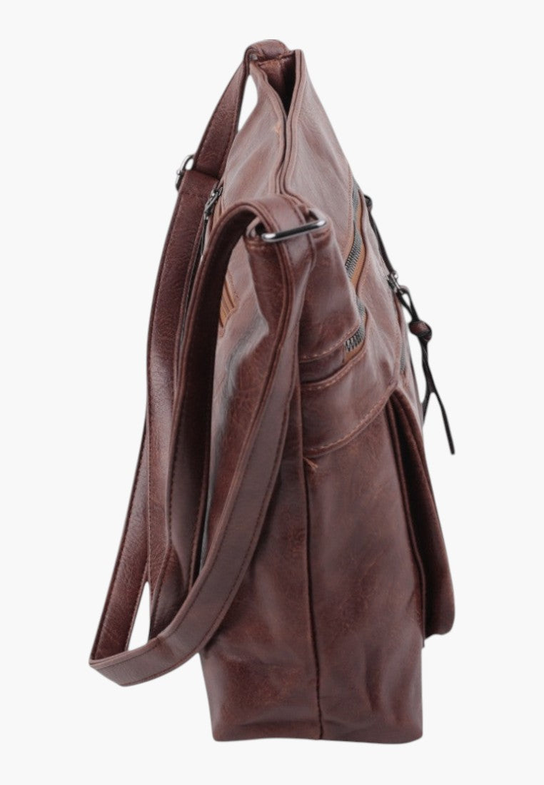 Side view of brown faux leather crossbody bag with adjustable strap and textured surface.