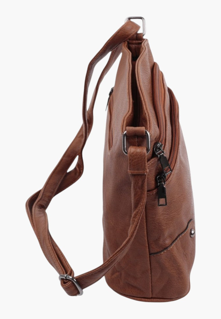 Side view of the brązowa torebka crossbody z regulowanym paskiem i bocznymi kieszeniami na zamek.