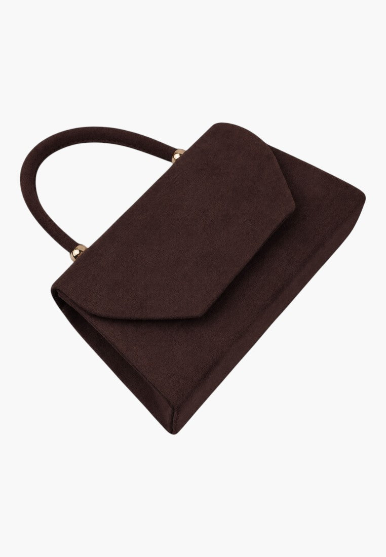 Detail close-up of a brown handbag showing the flap closure and top handle on a white background.