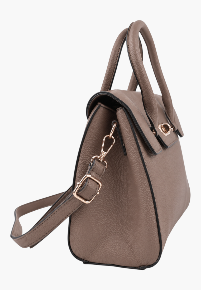 Detail shot of a brown handbag from the side showcasing gold hardware on a white background.
