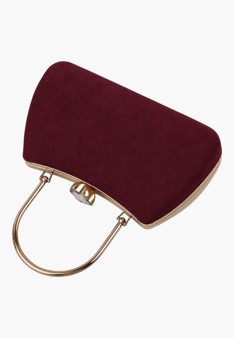 Angled view of a burgundy handbag showcasing its rounded shape and gold hardware