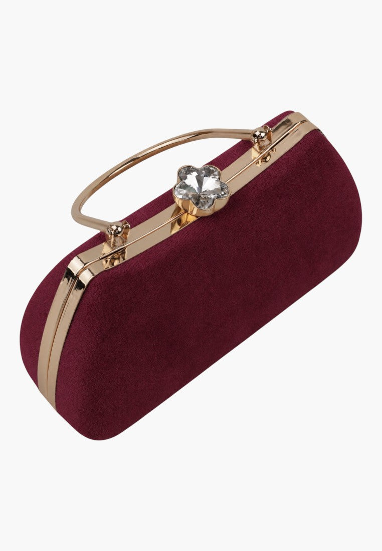 Detail close-up of a burgundy handbag highlighting the gold zipper and top handle