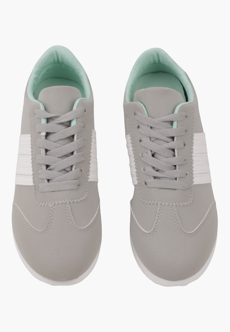 Widok z góry na szare sneakersy sportowe, sznurowane, na białym tle.