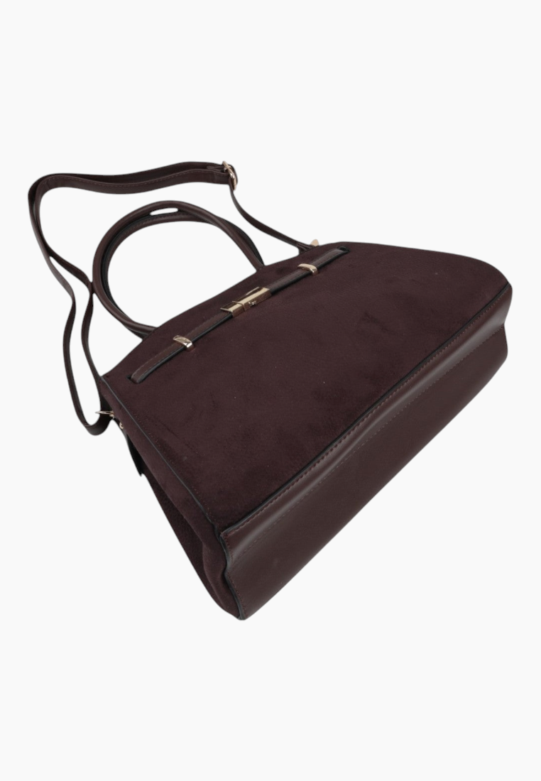 Side view of a brown handbag made of suede with double handles on a different background.