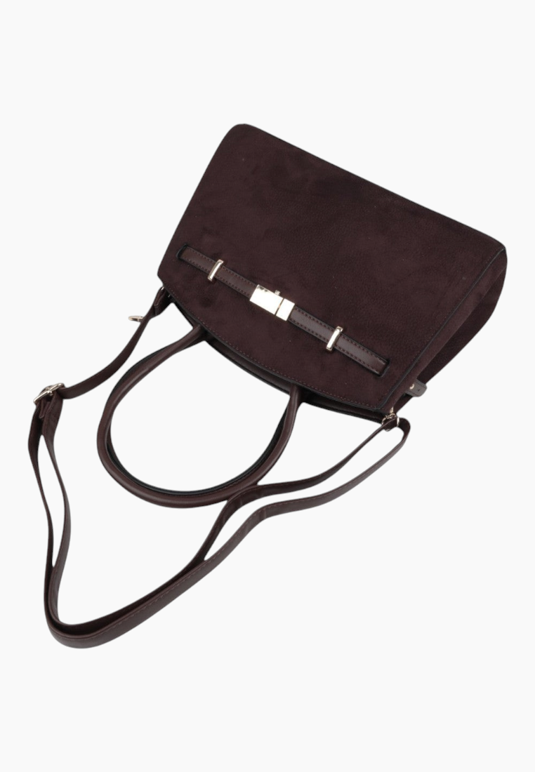 Detail shot of a dark brown handbag with a flap closure and adjustable strap on a white background.