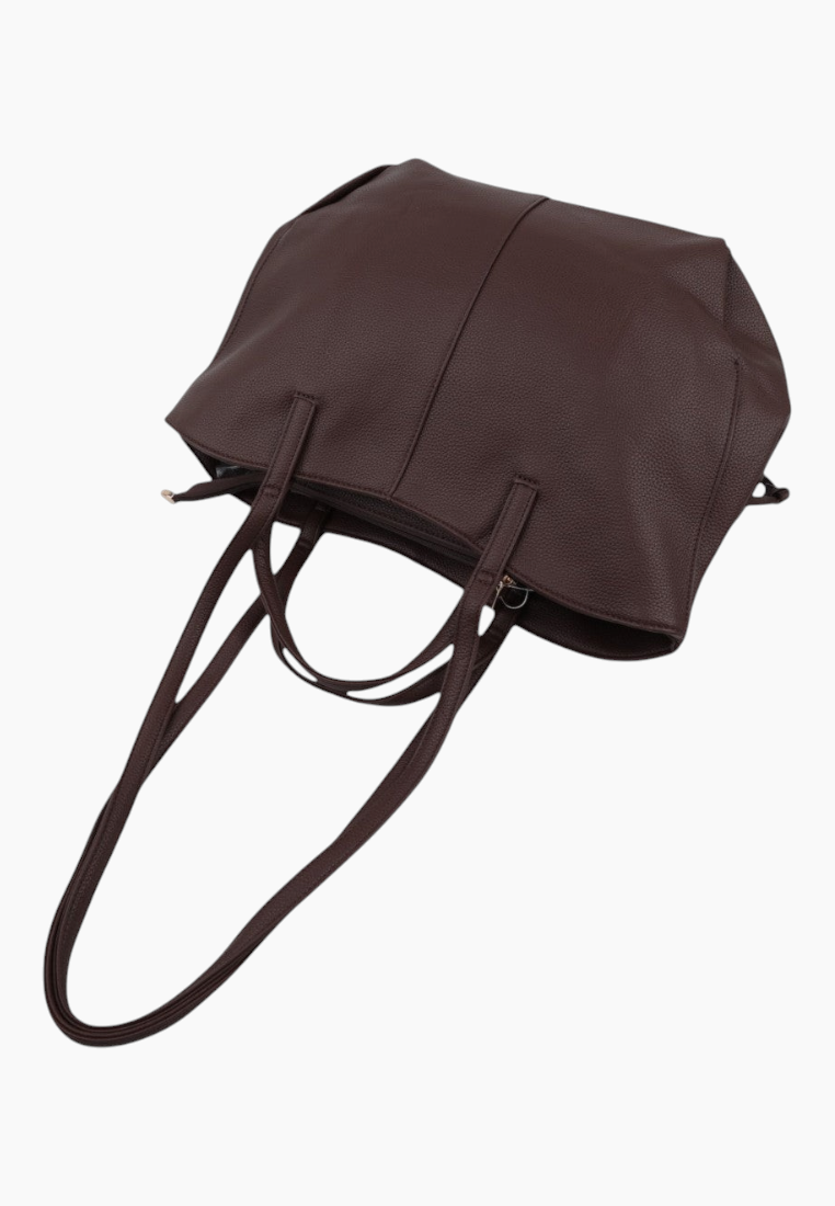 Side view of a brown tote bag with two handles on a white background.