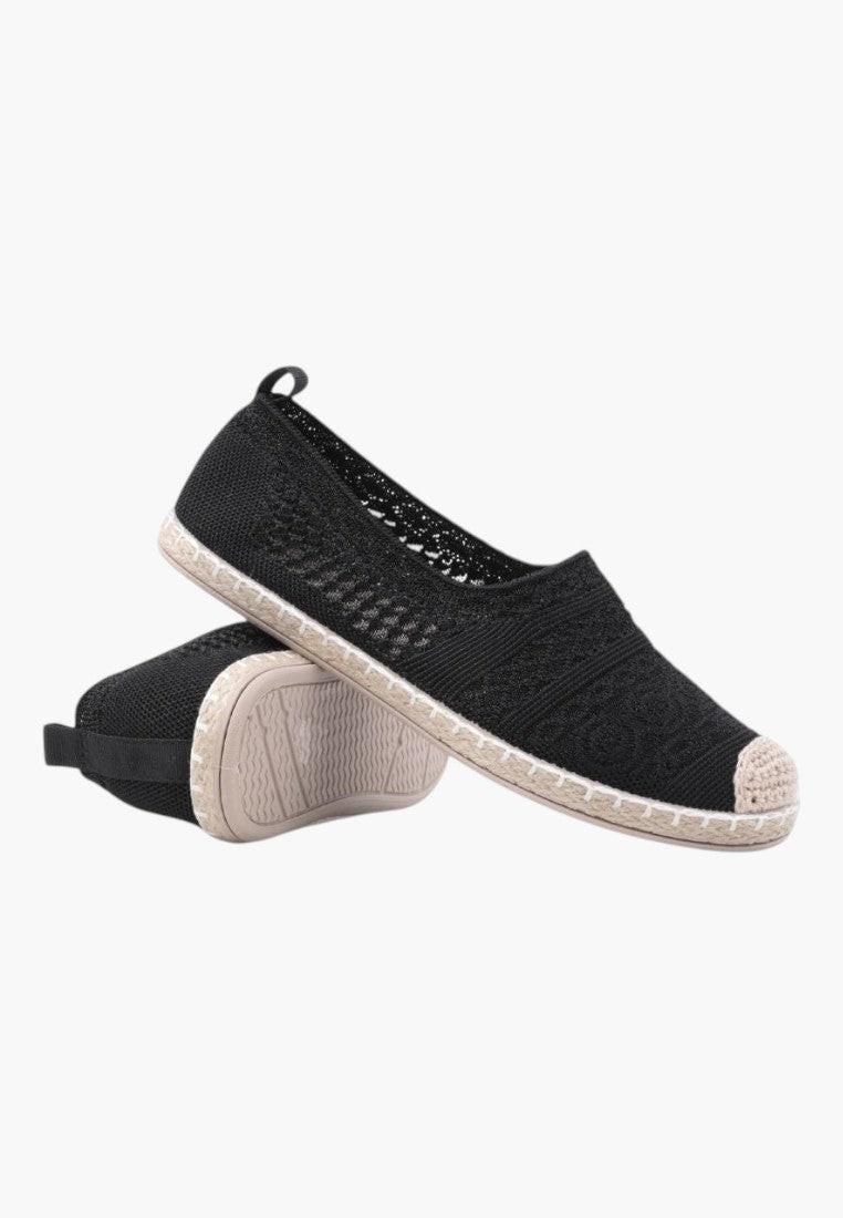 Czarne ażurowe espadryle z góry, minimalistyczny design na białym tle