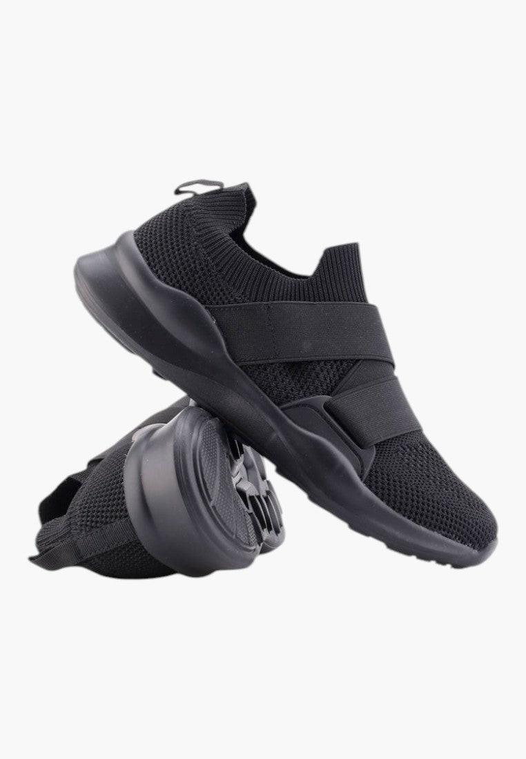 Czarne buty sportowe damskie z ekoskóry, stylizacja w codziennym otoczeniu