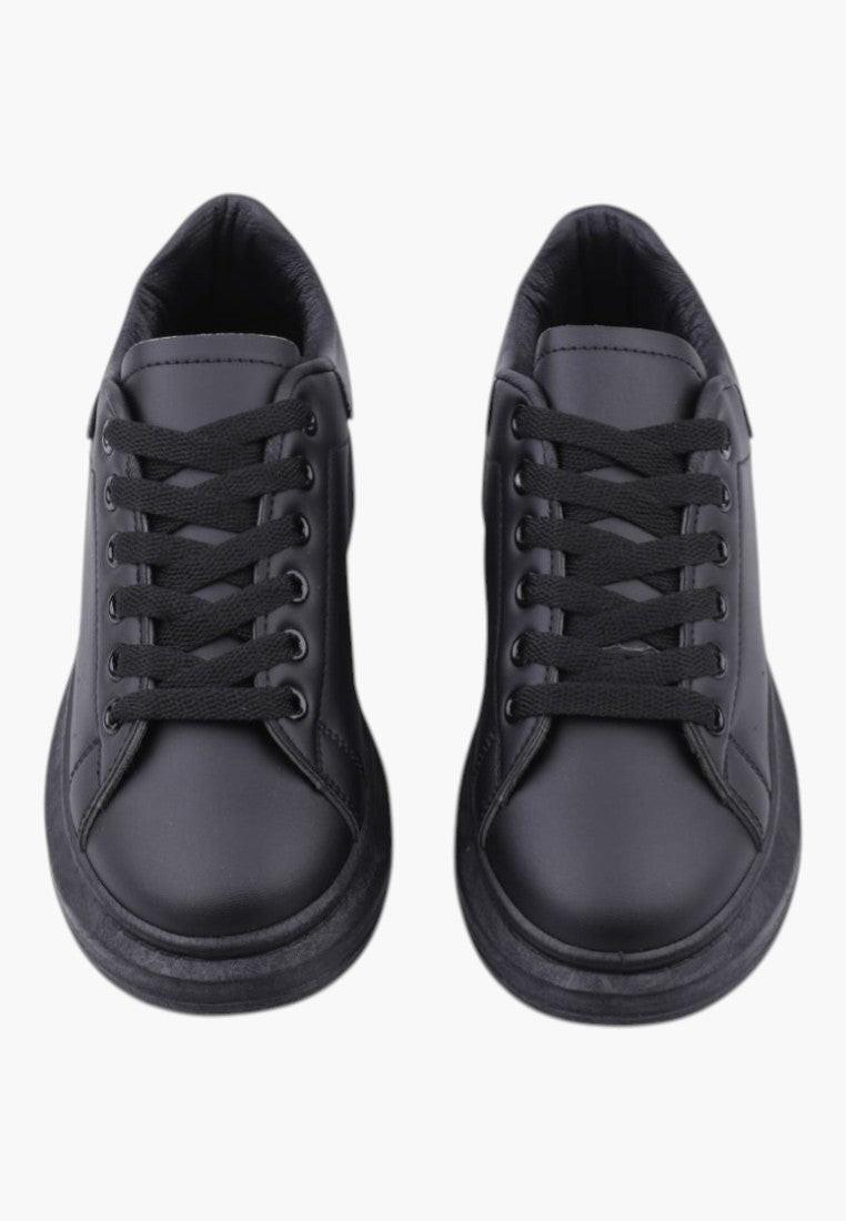 Close-up detail of black women's sneakers showcasing lace detail and textured upper