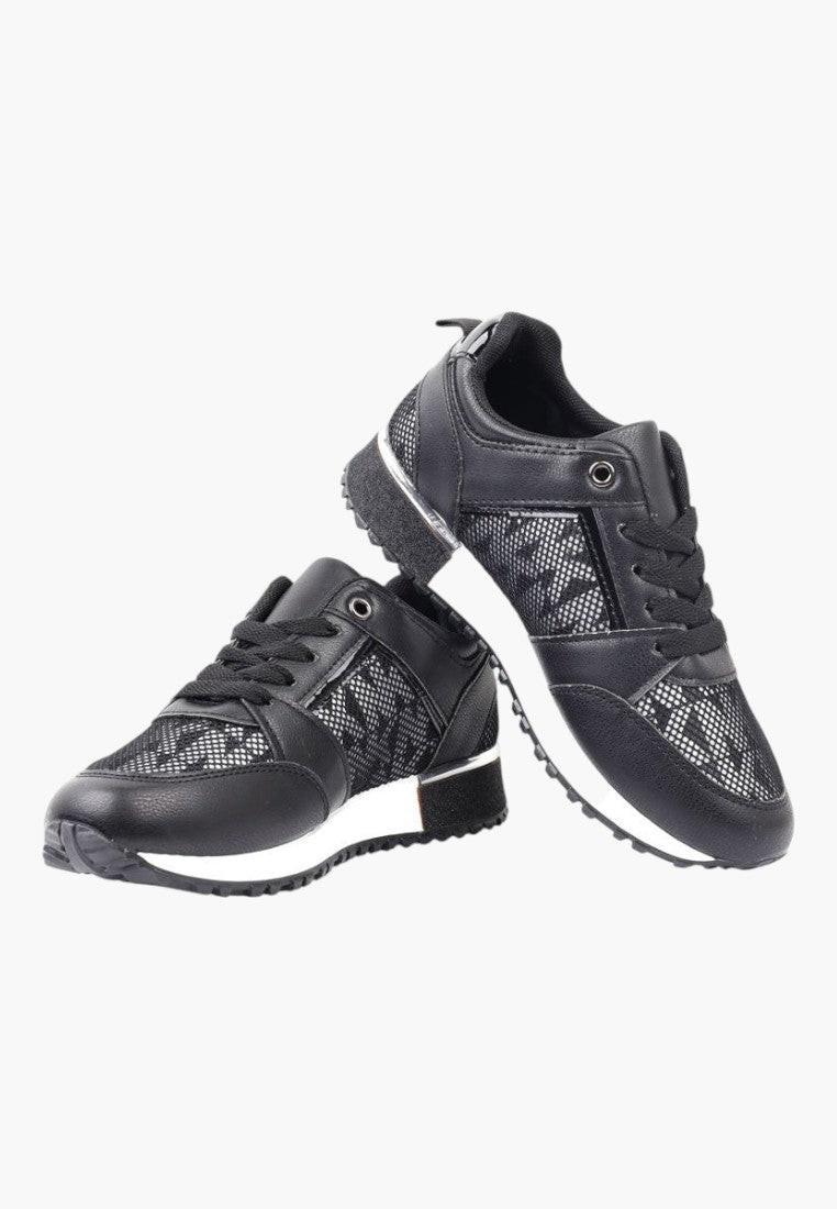 Zbliżenie na czarne sneakersy damskie z ekoskóry z ozdobnymi przeszyciami.
