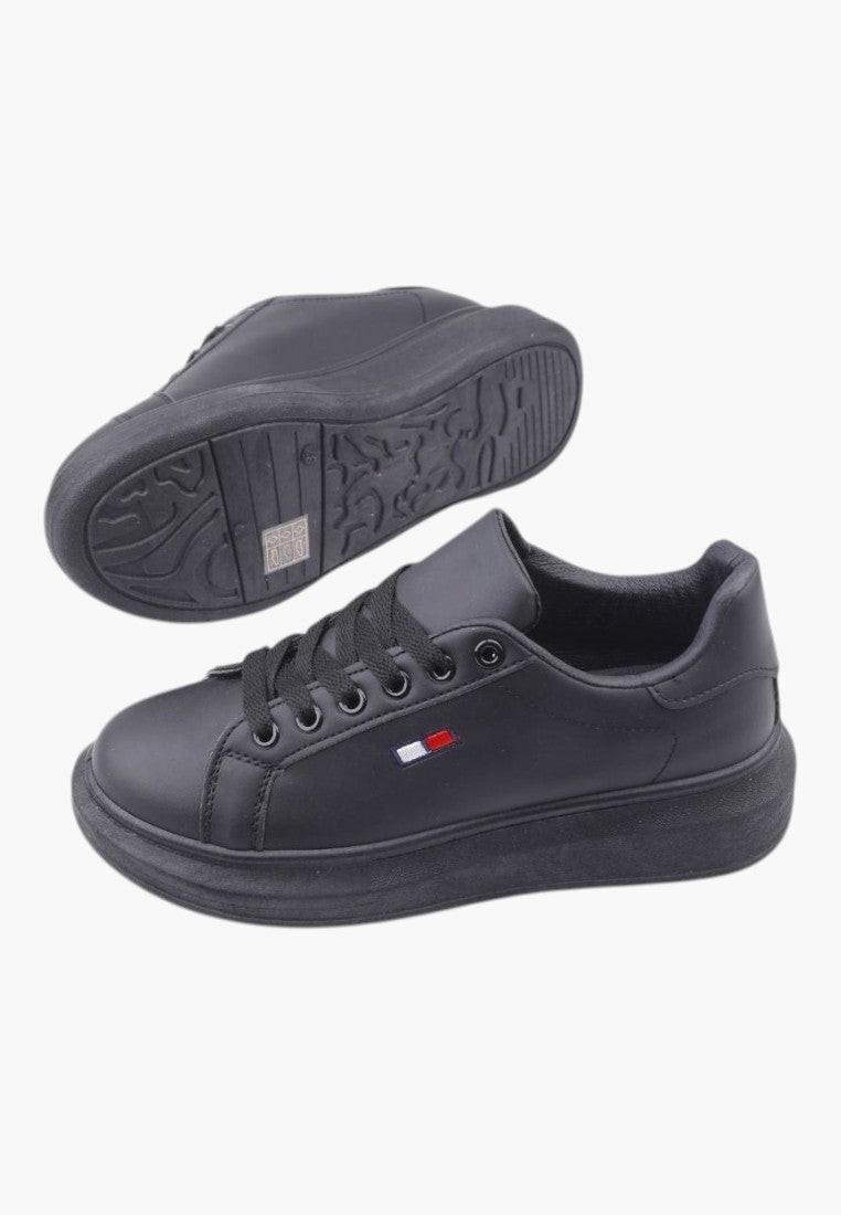 Widok z boku czarnych sneakersów damskich z ekoskóry z gumową podeszwą.